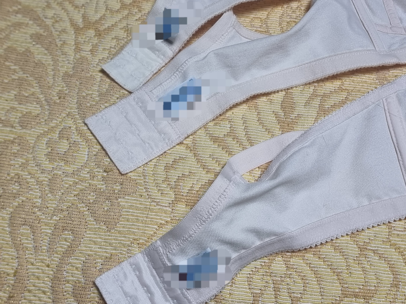 A view of the inside of a well-worn bra, where the label has completely faded away, showing its long history.