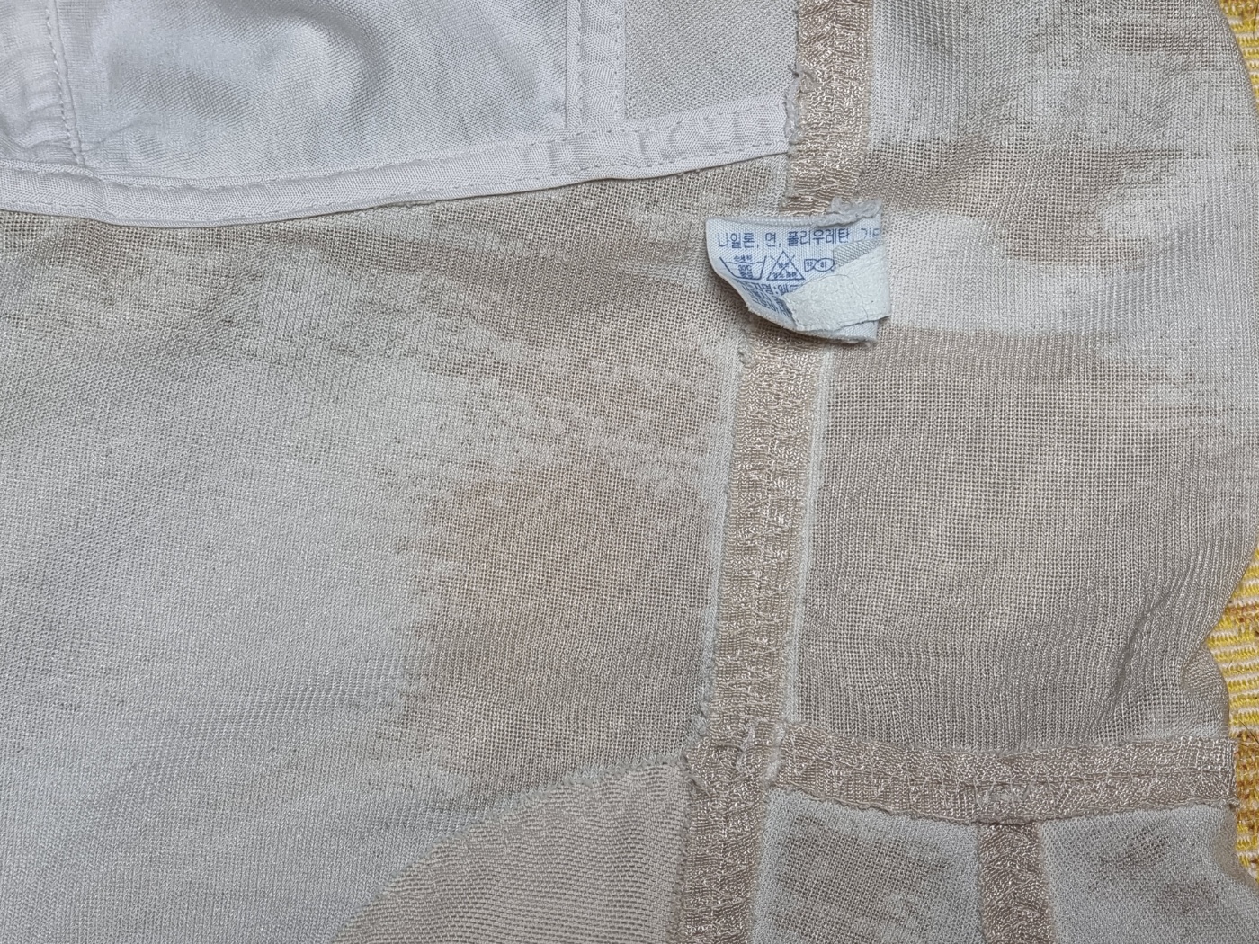 A close-up on the fabric of the aged shapewear, highlighting its durability.